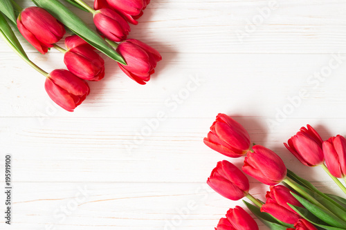 Fototapeta Naklejka Na Ścianę i Meble -  Bouquet of red tulips on white wooden background. Flat lay. Copy space.