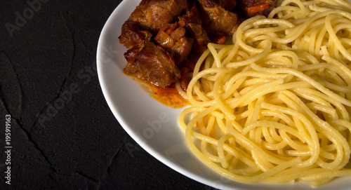 Italian spaghetti with beef meat in white plate on dark concrete background