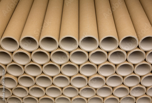 A bunch of brown industrial paper core. A lot of paper cores or paper tubes. Brown paper rolls.