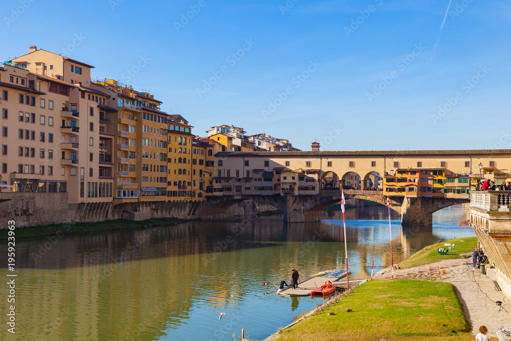 FLORENCE, ITALY - DECEMBER 23, 2017: Arno river, houses and old Ponte Vecchio bridge, Florence, Tuscany, Italy