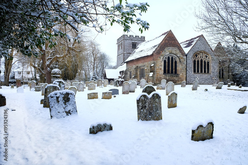 Ringmer church, East Sussex, uk the church the grave stones and grave yard in the foregeground snow on the ground and on the church photo