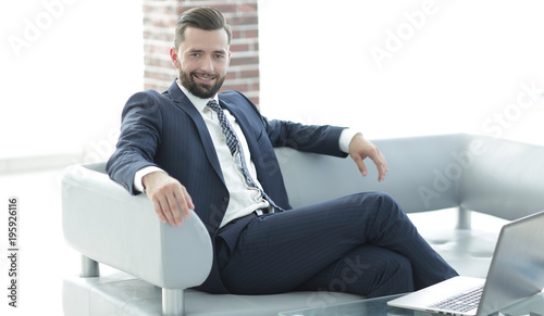 Portrait of a successful businessman sitting in the office lobby.