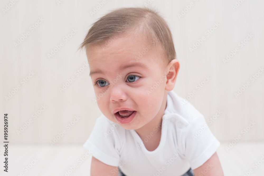 Blue-eyed baby boy on white wooden background