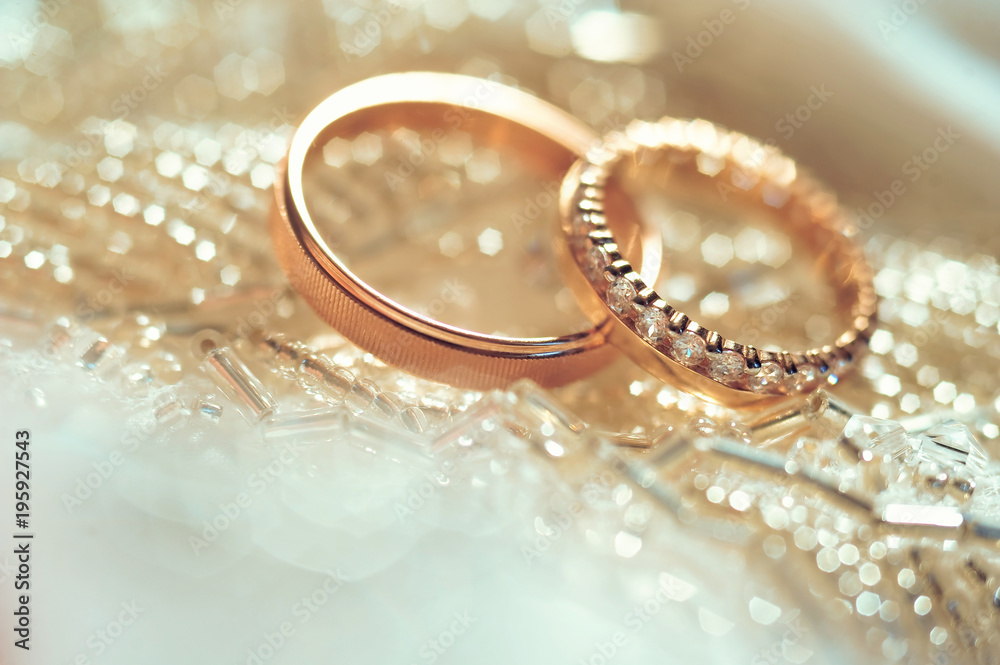 Wedding rings, jewelry and symbols attributes taken with selective focus. Holiday, celebration. Macro. Blur. Bridal bouquet on background Wedding rings, jewelry and symbols attributes taken with selective focus. Holiday, celebration. Macro. Blur. Bridal bouquet on background