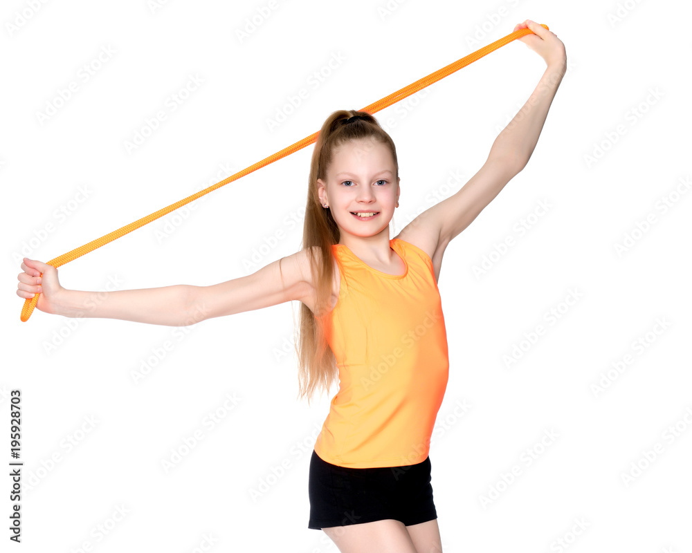 A girl gymnast performs exercises with a skipping rope. A girl gymnast performs exercises with a skipping rope.
