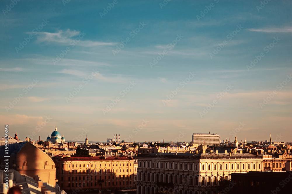 Panoramic view of the roofs with ventilation holes and chimneys, spiers, towers, domes of churches and cathedrals in the summer evening. Saint-Petersburg, Russia.
