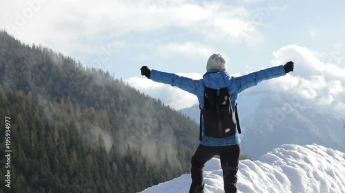 Woman standing on mountain peak with arms outstretched, Alps, Austria