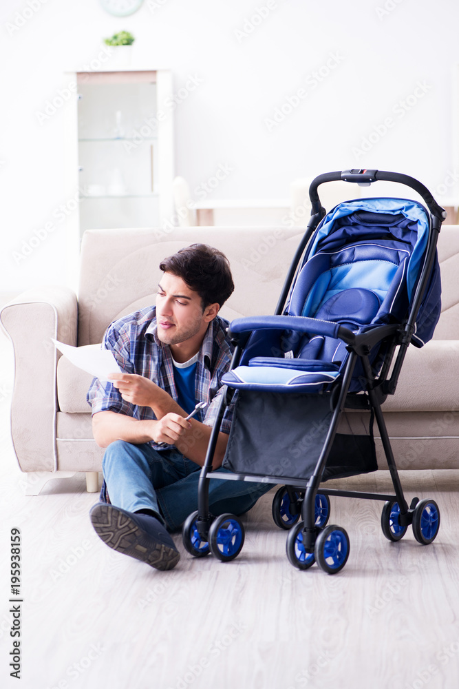 Young father assembling baby pram at home Young father assembling baby pram at home