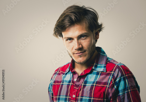 caucasian man wearing checkered shirt and trendy hairstyle