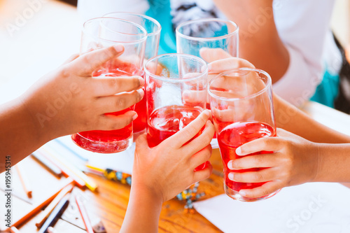 Canvas Print Group of asian children clinking glasses of fresh red juice water with ice and d