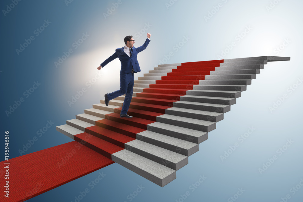 Young businessman climbing stairs and red carpet Young businessman climbing stairs and red carpet