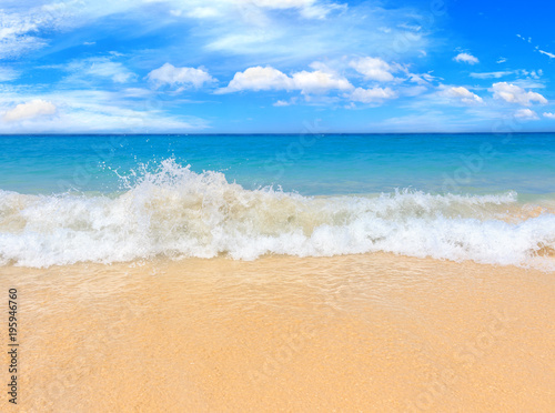 Picturesque view of Andaman sea with strong and high waves in Phuket island  Thailand. Seascape with yellow sand and blue sky. Tropical beach at the exotic island.