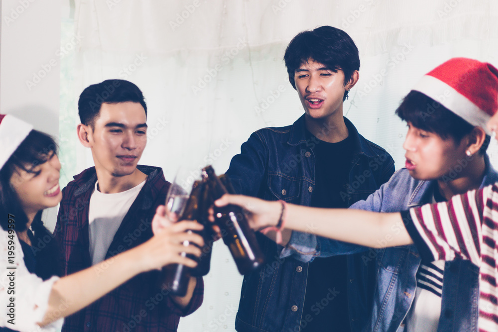Naklejka premium Asian group of friends having party with alcoholic beer drinks and Young people enjoying at a bar toasting cocktails.soft focus