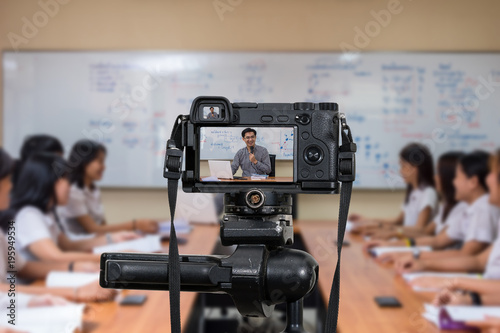 Professional digital Mirrorless camera on the tripod recording video blog of Asian teacher in the classroom, Camera for photographer or Video and Technology Live Streaming concept,education concept