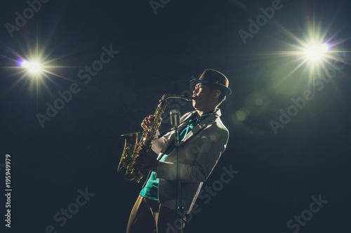Photography Asian Musician playing the Trumpet with spot light and lens flare on the stage,
