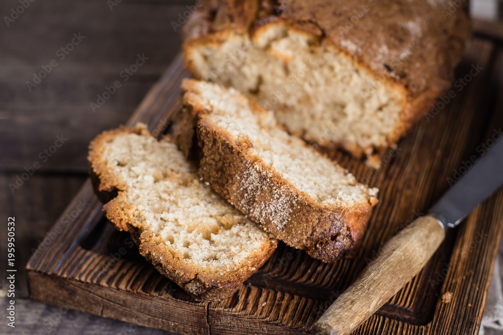 Homemade cinnamon cake bread on rustic wooden board on background table