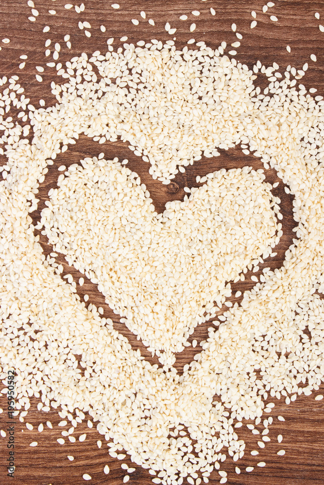 Heart of sesame seeds on board, healthy nutrition concept and sumbol of love