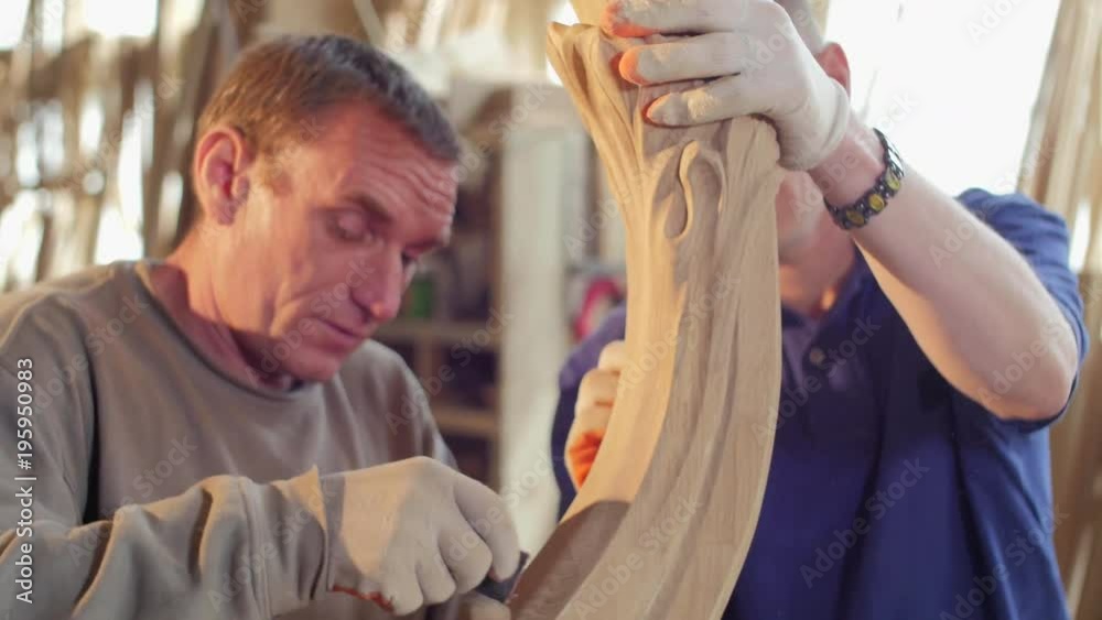Men sanding a wooden decoration Men sanding a wooden decoration