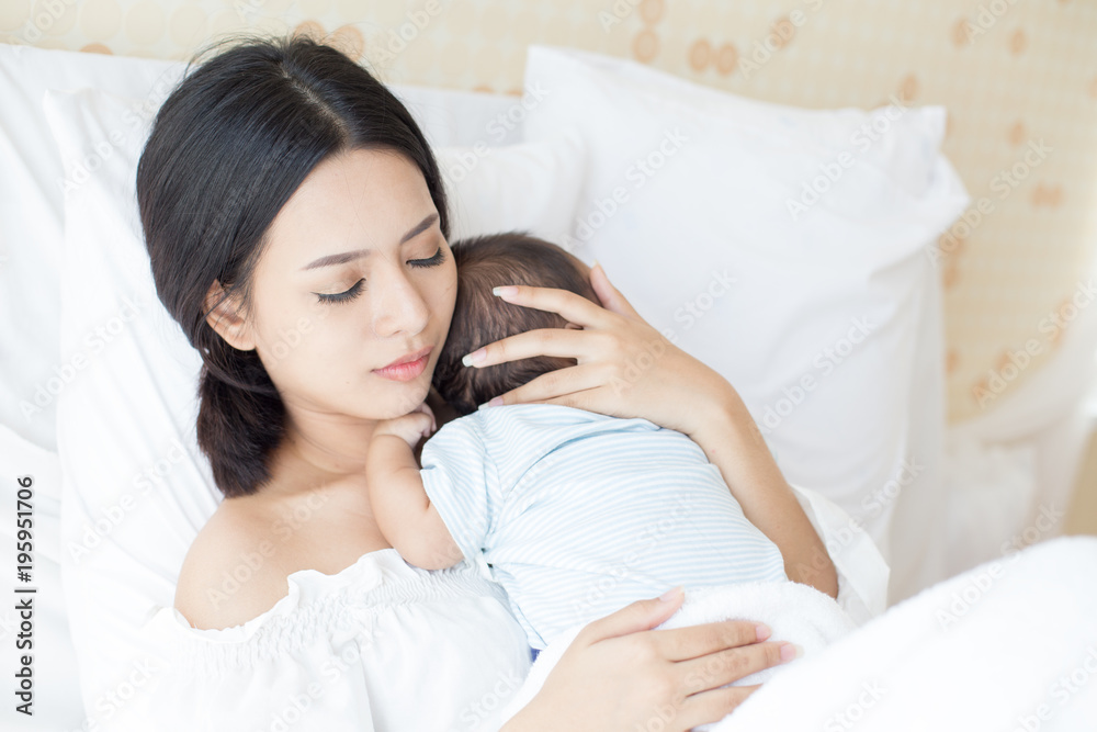 Portrait of Mother and new born baby on a white bed. Portrait of Mother and new born baby on a white bed.