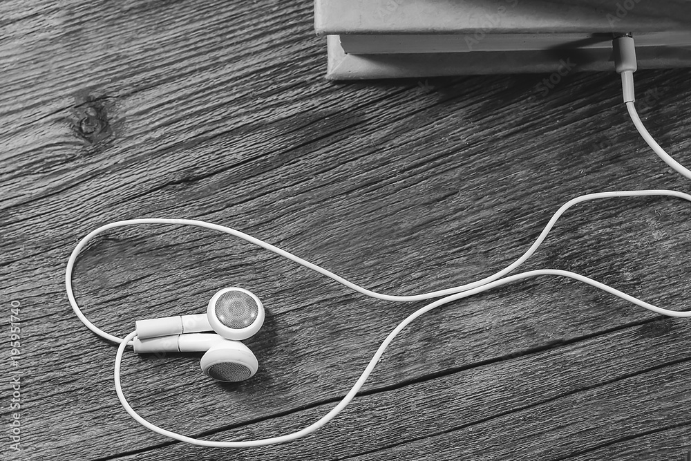 white headphones and a book. audiobook concept white headphones and a book. audiobook concept