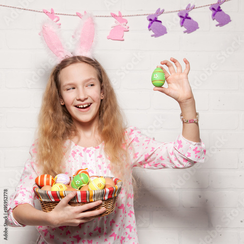 Child is holding a basket with Easter eggs