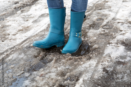 Standing in puddle in rubber boots, spring, melting snow.
