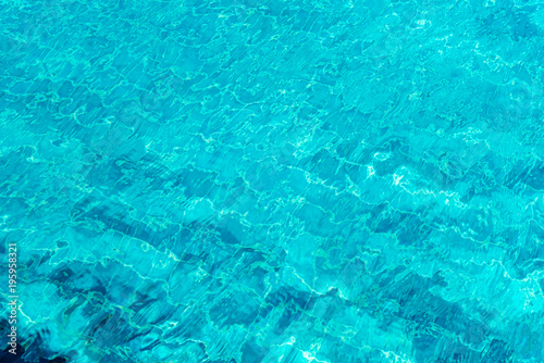A close up shot of water in swimming pool as the sunlight reflection. Abstract background.