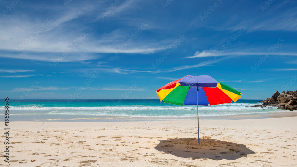 Tropical beach with colorful umbrella. Fashion travel and tropical beach concept. 