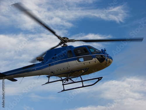 Blue helicopter on sky with clouds