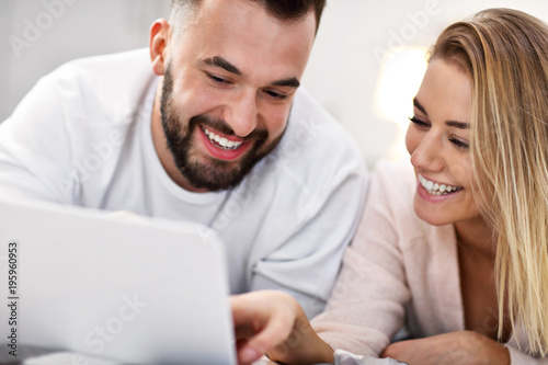 Adult couple with laptop computer in bed