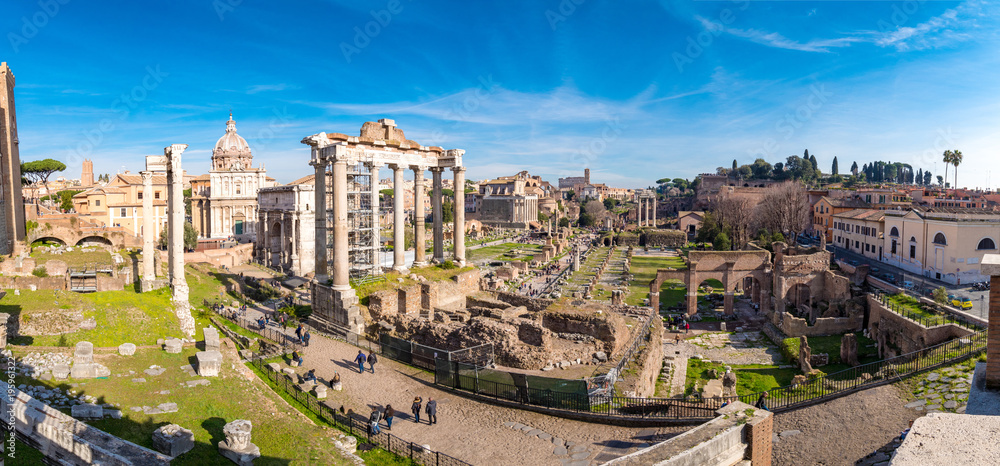 The ruins of the Roman Forum in Rome, Italy with the Colosseum visible in the back