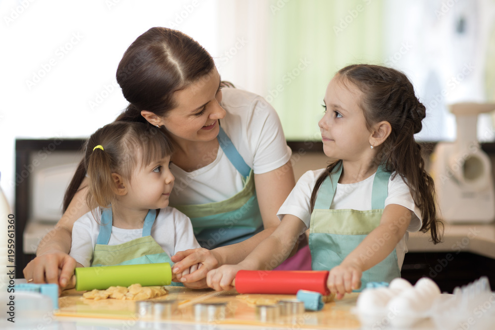 Family mom and daughters baking cookies in kitchen together