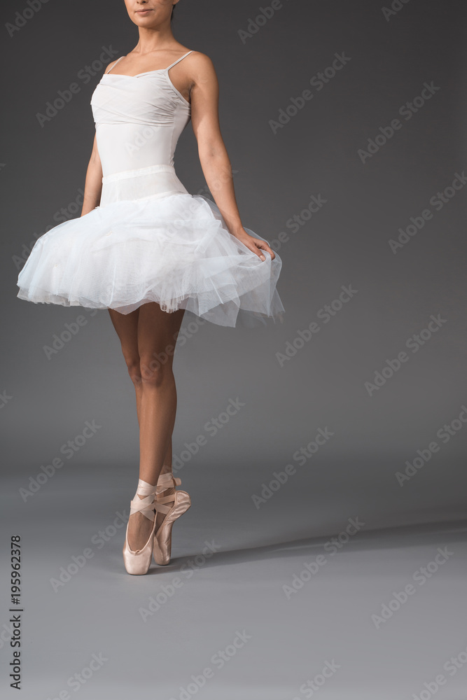Gracefulness concept. Slim woman in tutu rising at the tips of her fingers. Copy space in right side Gracefulness concept. Slim woman in tutu rising at the tips of her fingers. Copy space in right side