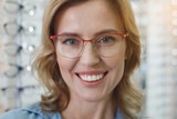 Portrait of woman wearing spectacles while expressing happiness in optician shop. Ophthalmology concept