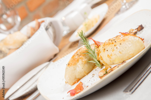 Traditional polish dish called kartacz - potato dumplings stuffed with meat and served with crispy bacon, caramelized onion and fried boletu photo