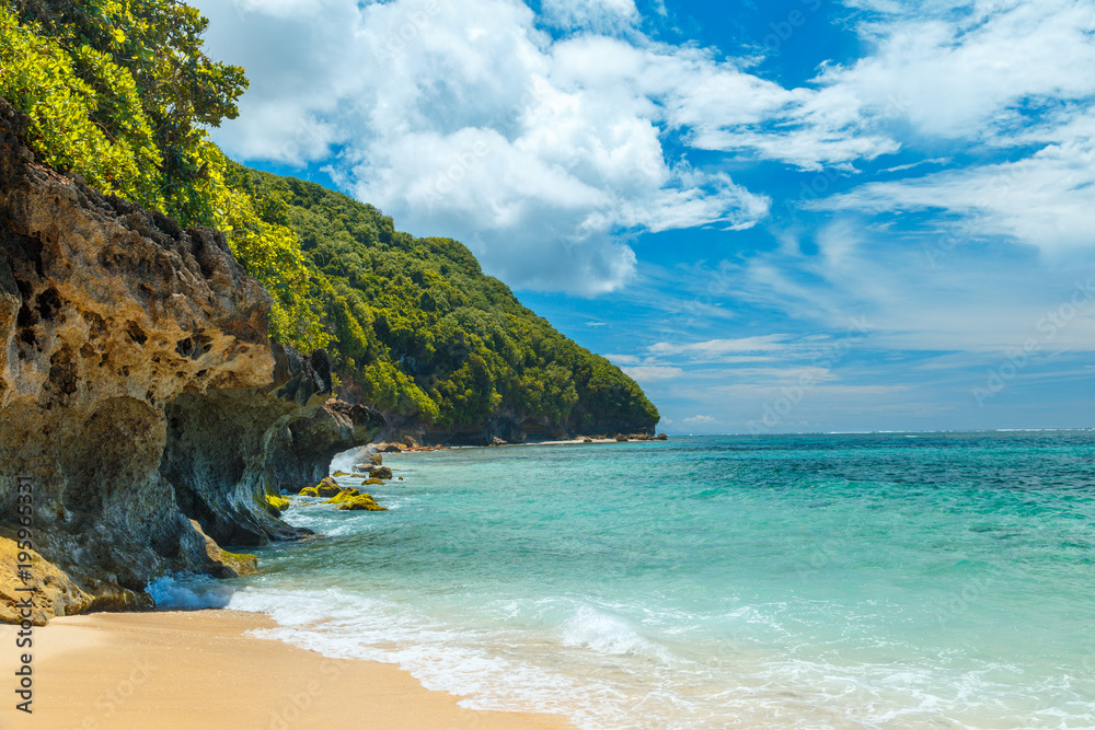 Panorama tropical Bingin Beach Bali on background hotel in traditional balinese style, bungalow, mountains, beautiful cloudy sky and azure sea ocean water on horizon. Bali, Indonesia.