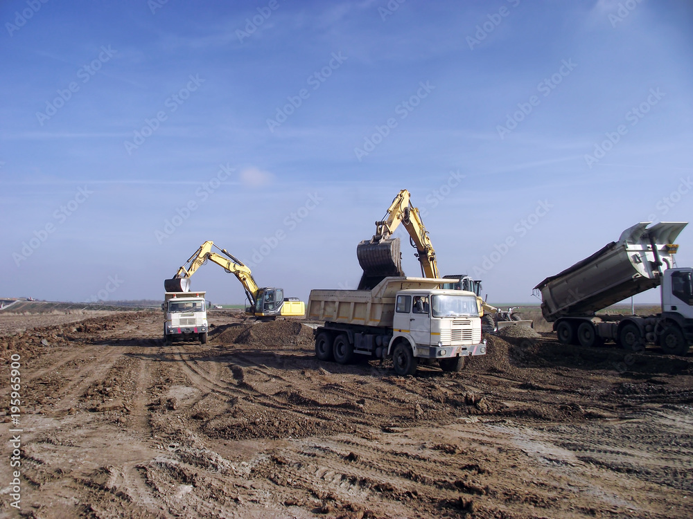 Obraz premium Excavators load trucks