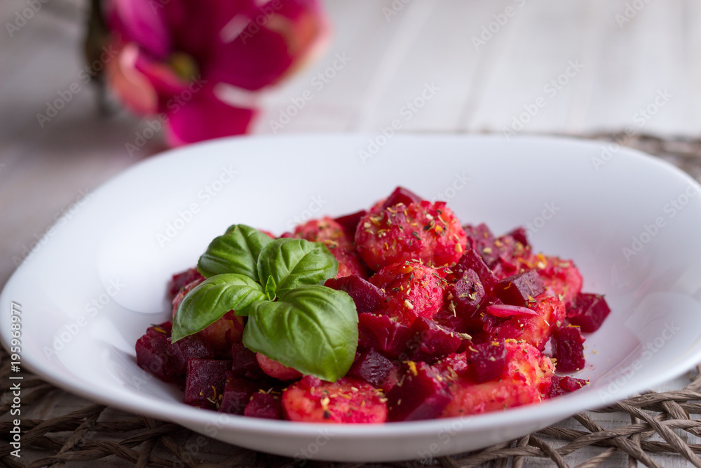 Home-made gnocchi and beet root on white plate Home-made gnocchi and beet root on white plate