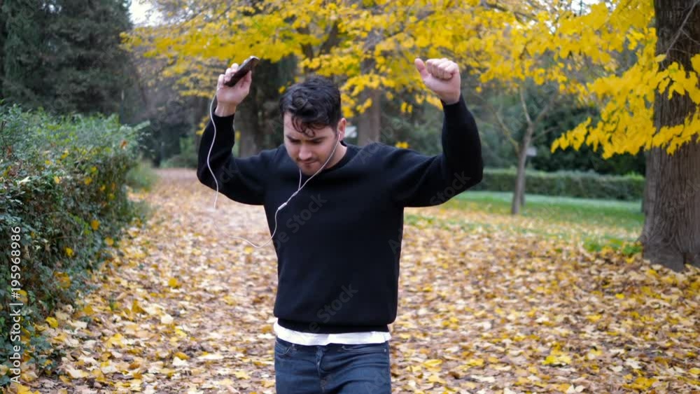 funny and happy young man dancing in the park- slow motion funny and happy young man dancing in the park- slow motion
