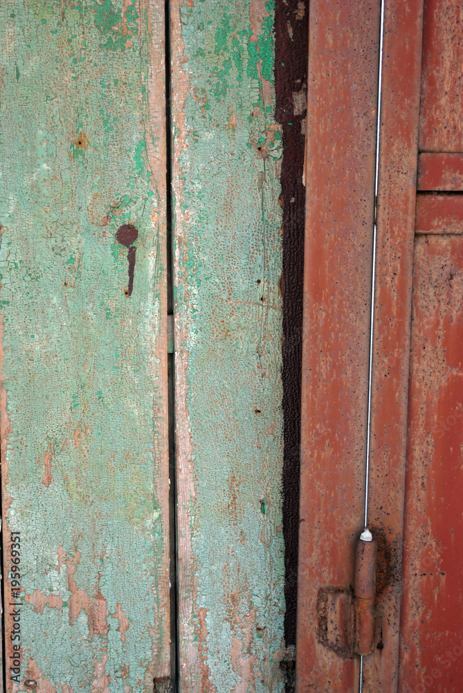Door frame with shabby green and door with  handle of dark red color, grunge texture background