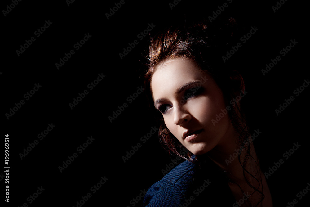 Girl in fashion style looks inside a close-up on a black background with space for text Girl in fashion style looks inside a close-up on a black background with space for text
