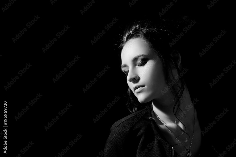 Studio portrait of a girl with evening make-up on closed eyes in fashion style in a low key on a black background with space for text Studio portrait of a girl with evening make-up on closed eyes in fashion style in a low key on a black background with space for text