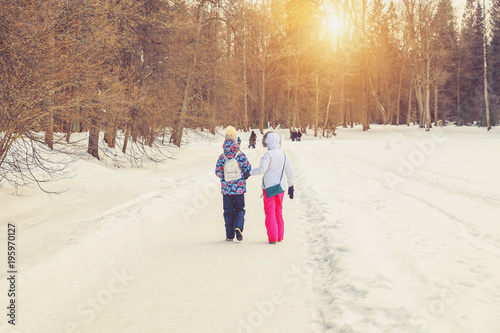 Mom and daughter in the park in the winter at sunset in Russia