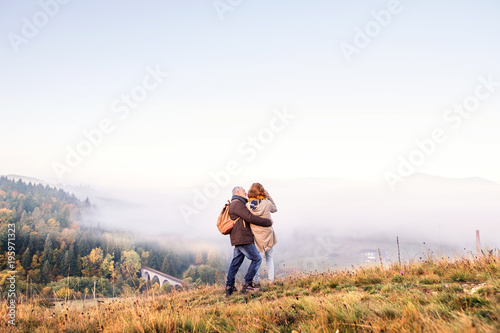 Senior couple on a walk in an autumn nature. © Halfpoint