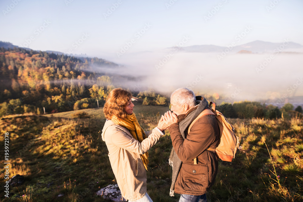 Senior couple on a walk in an autumn nature.