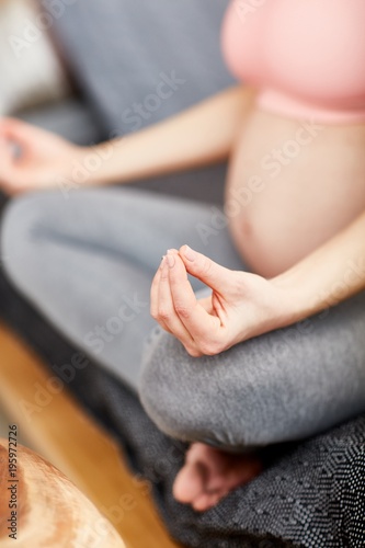 Pregnant woman doing yoga exercise - meditation.