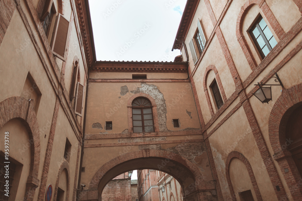 Archway between two buildings in historical quarter of Siena