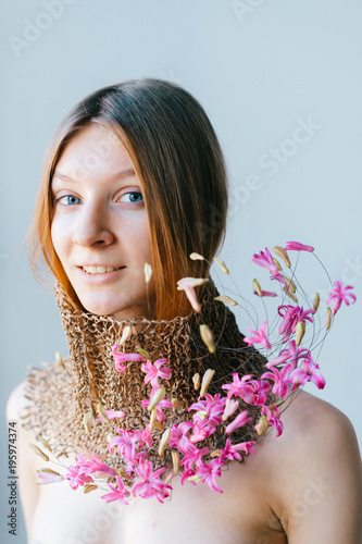 Creative mood portrait of young blue eyed beautiful girl isolated on white and black background. Unusual art designed flower composition. Fashion style. Pretty woman with original handmade decorating. photo