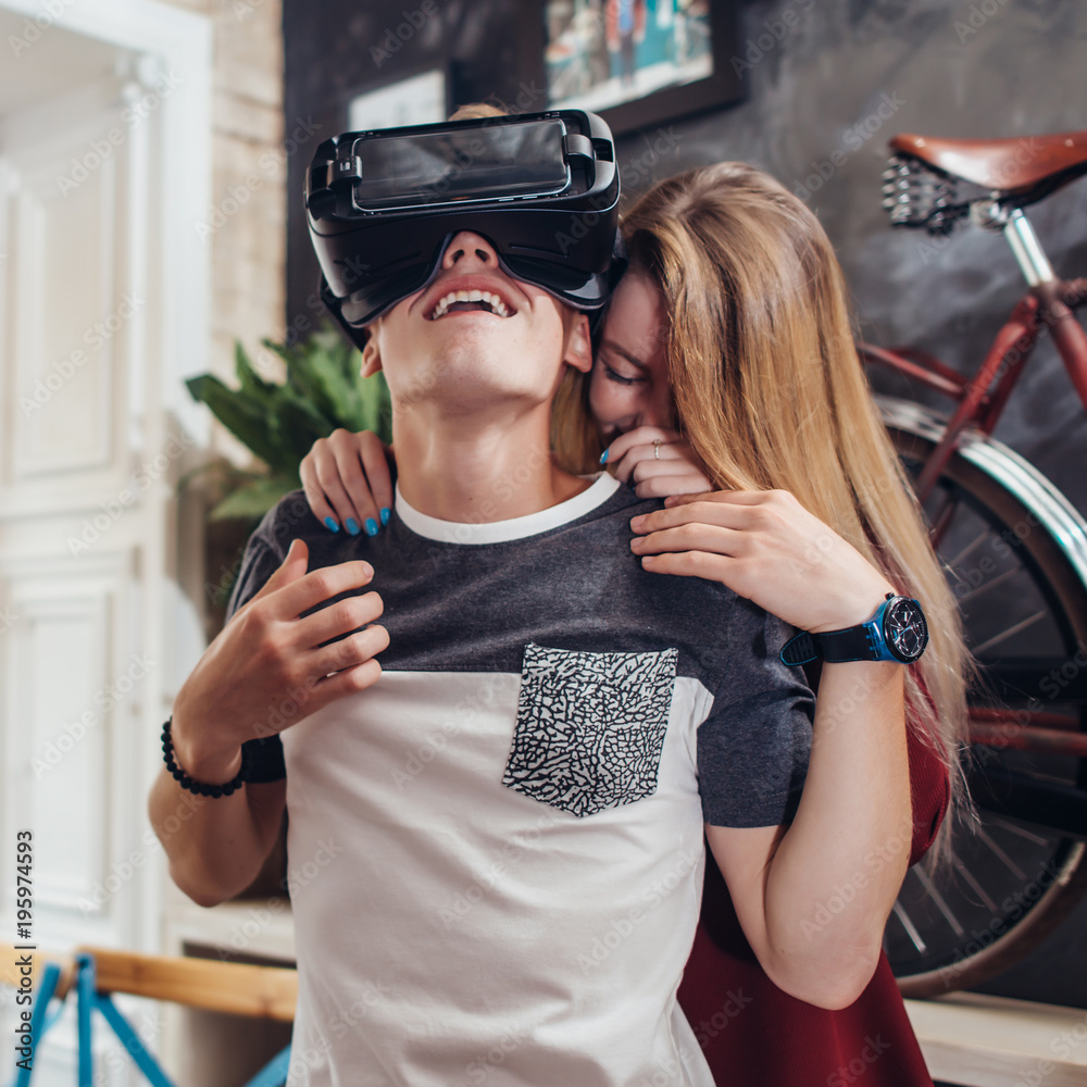 Boyfriend and girlfriend testing new vr 3d vision headset spending time together having fun laughing at home Boyfriend and girlfriend testing new vr 3d vision headset spending time together having fun laughing at home