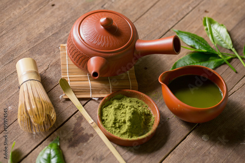 Matcha Green Tea and Japanese tea set. Ceramic teapot and a steaming cup on wooden background © kaiskynet